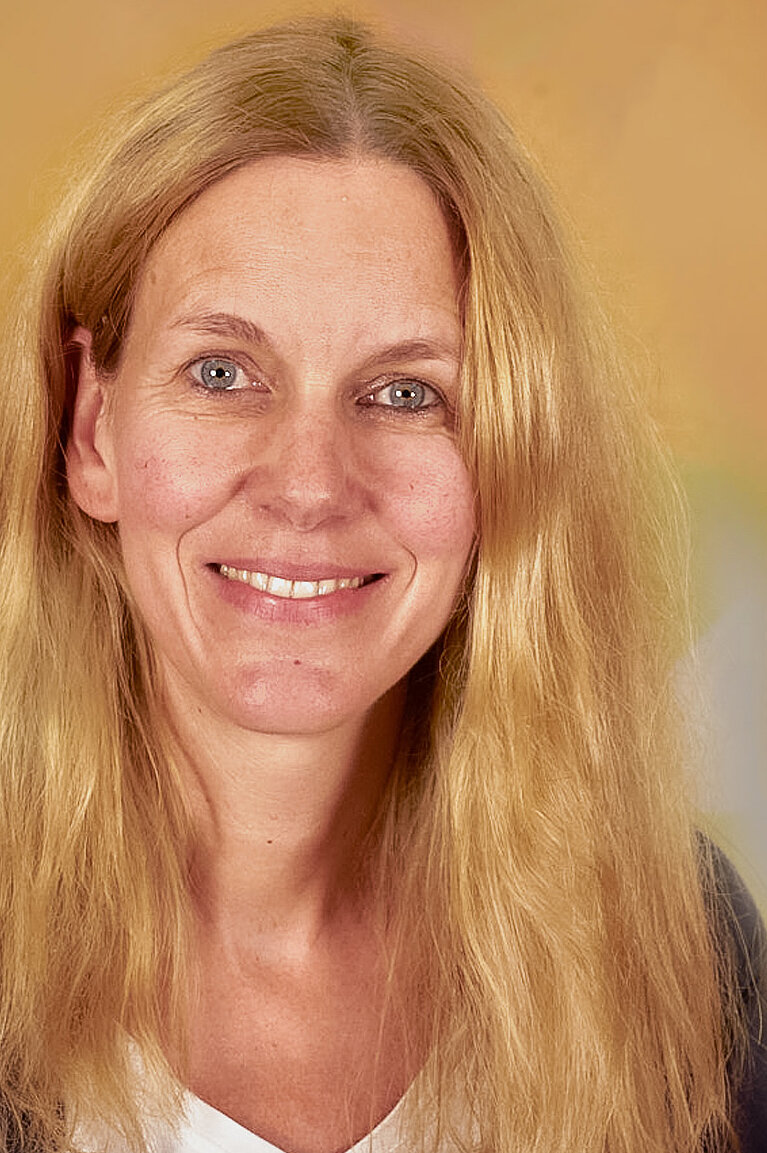 Andrea Raumann im Portait freundlich lächelnd.